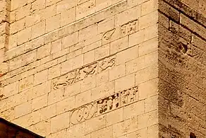 Sculptures romanes et marques de tâcheron sur le transept de la cathédrale Notre-Dame de Saint-Paul-Trois-Châteaux.