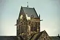 Mannequin de John Steele et son parachute sur le clocher de l'église de Sainte-Mère-Église.