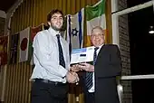 Photographie d'un homme donnant un prix à un autre homme