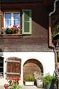 Maison à Schwarzenburg, canton de Berne. Façade couverte de bardeaux arrondis.