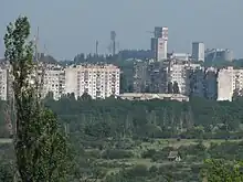 Mine au loin, derrière des immeubles d'habitation et des espaces verts
