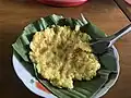 Riz huileux pilé façon shan - servi sur une feuille de bananier aux racines ailées.