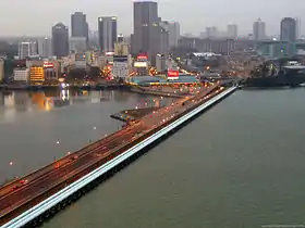La chaussée Johor-Singapour vue de Woodlands Checkpoint à Singapour, en face se trouve Johor Bahru, la capitale de l'État de Johore en Malaisie. À droite de la chaussée en blanc : les canalisations qui permettent à Singapour d'être approvisionnée d'eau douce depuis la Malaisie.