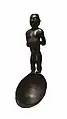 Cuiller en bois avec manche sculpté en forme de figure féminine.