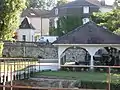 Le lavoir, derrière lequel se voit le poids public.