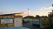 Portail avec un terrain de football en fond.