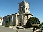 Vue latérale, clocher roman élancé et abside couverte de lauses.