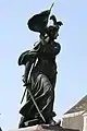 Vue en pied, Jeanne d'Arc est en robe flottante, une esthétique en décalage pour cette période néo-classique.
