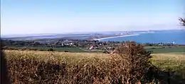Un paysage de bord de mer, avec un château en ruine.