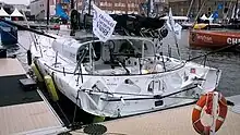 Voilier blanc vu de l'arrière, amarré au ponton.
