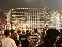 Photo d'un ring hexagonal surplombé d'une cage