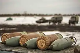 Des obus explosifs à fragmentation de 125&nbsp;mm accompagnés de leurs charges propulsives respectives.