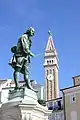 Le monument à Tartini et en arrière-plan le campanile de l'église Saint-Georges (sl).