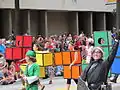 Défilé dans la rue, avec des personnes déguisées en tétriminos.