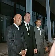 Photographie couleur des trois hommes d'équipage souriant et en costumes.