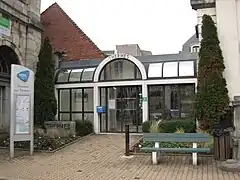 Photographie en couleurs de l'entrée d'un bâtiment, vue de face.