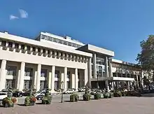Photographie en couleurs d'un long bâtiment style XIXe siècle.