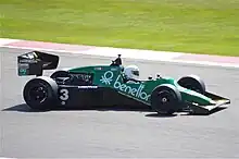 Photo d'une monoplace verte et noire en piste.