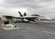 Sur le pont d'envol, un avion est en cours de catapultage.