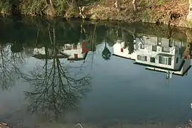 Photographie du reflet d’une maison dans un plan d’eau.