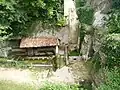 Le site, avec la fontaine et la grotte à droite.