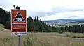 Balisage du sentier de la randonnée de longue distance Via Transilvanica, avec un avertissement sur l'éventuelle présence des ours