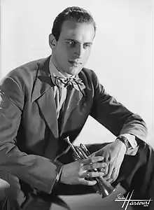 Sur cette photo en noir et blanc, Boris Vian est assis, tourné vers la droite de l'image, le regard dans le vide. Il porte un costume et un nœud papillon, et tient dans ses mains une petite trompette, qu'il appelait « trompinette ».