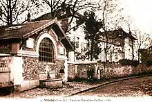Vue de bâtiments du début du XXe siècle en bord de rue sur une carte postale ancienne.