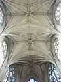 Plafond en briques claires, avec voûtes de style gothique et clés de voûte.