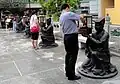 Statues tenant des lampes où est brûlé de l'encens