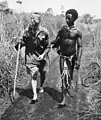Un autochtone, Raphael Oimbari, aide un soldat australien blessé, George Whittington, durant la campagne de Nouvelle-Guinée. Les auxiliaires autochtones sont célébrés par les Australiens comme étant des «&nbsp;anges aux cheveux crépus&nbsp;» (en)