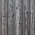 Façade ancienne en yakisugi : le bois mis à nu sous le charbon a grisé, les nœuds sont restés brûlés.